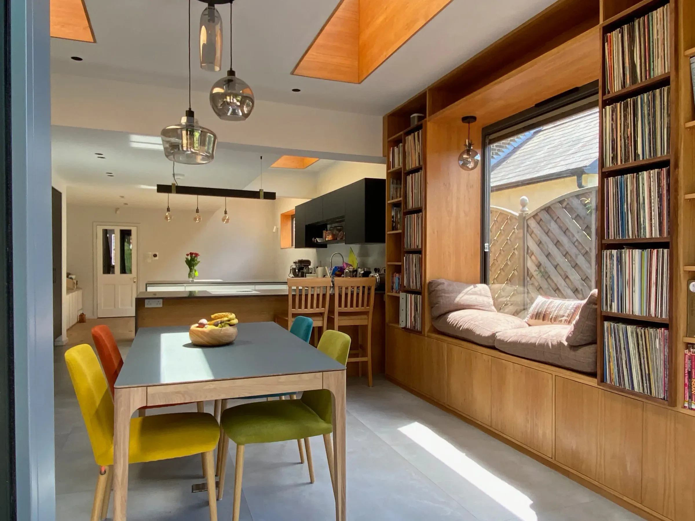 A kitchen and dining extension with timber-lined rooflights, a window seat and built-in bookshelves.