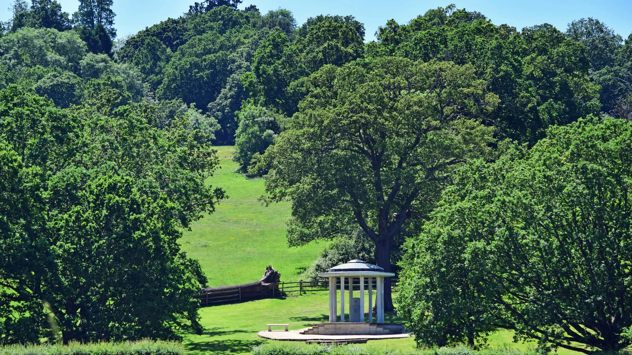 The domed Magna Carta Memorial in the meadows at Runnymede, framed by mature trees