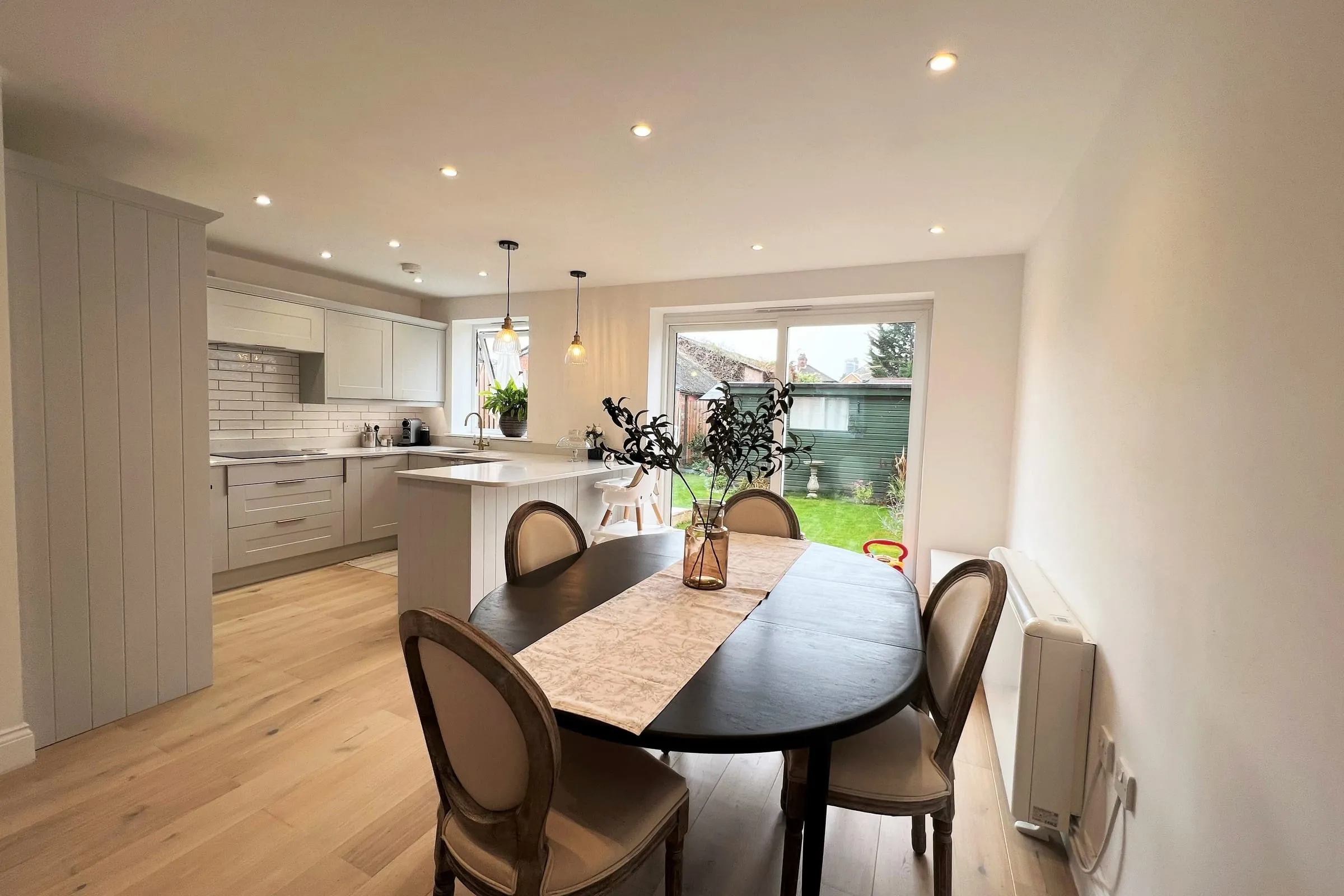 The kitchen and dining room in the extended Woking end-of-terrace, with a round table and a window onto the garden