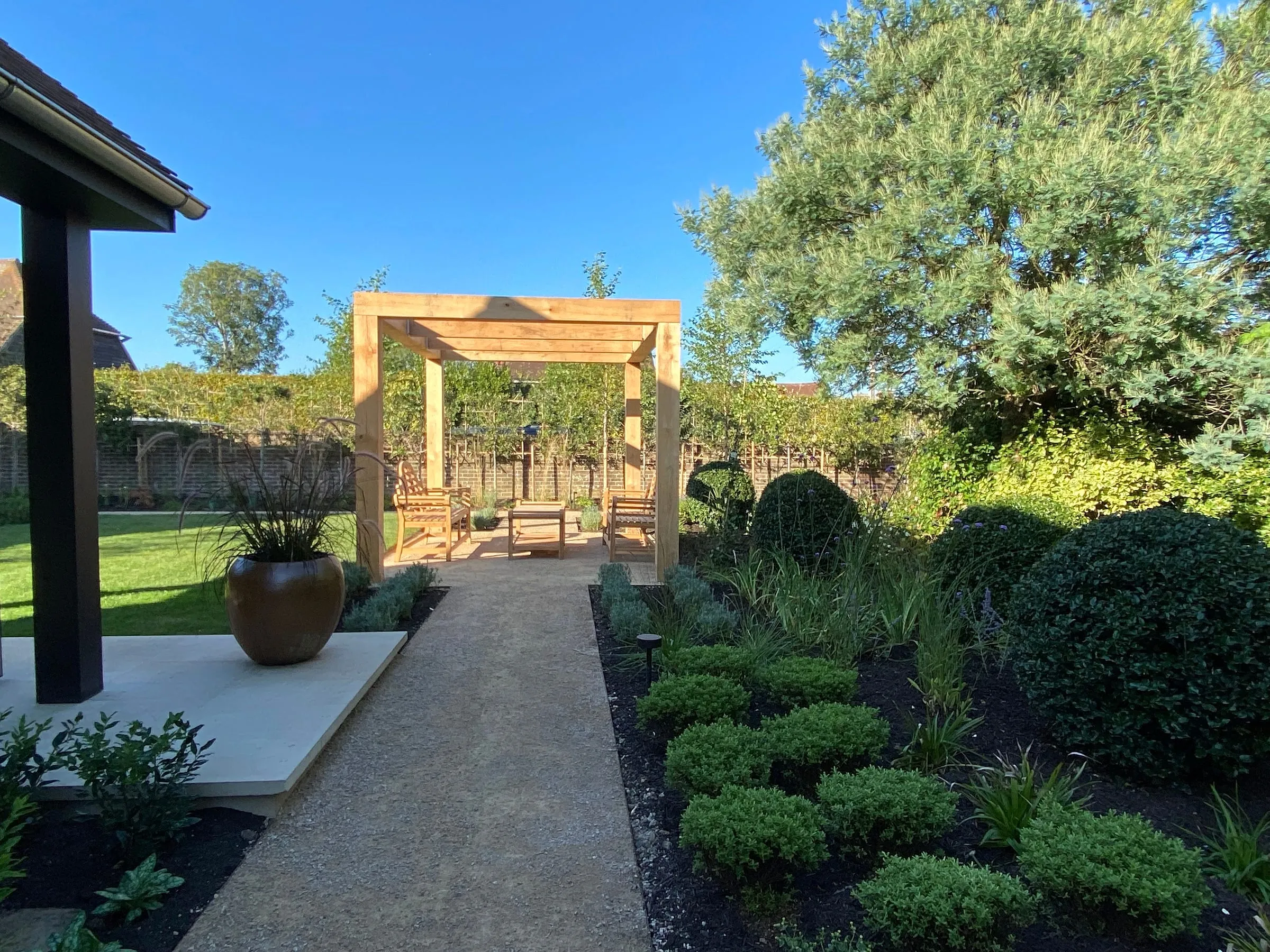 The new planting and path beside the lawn, with the pergola and garden room beyond