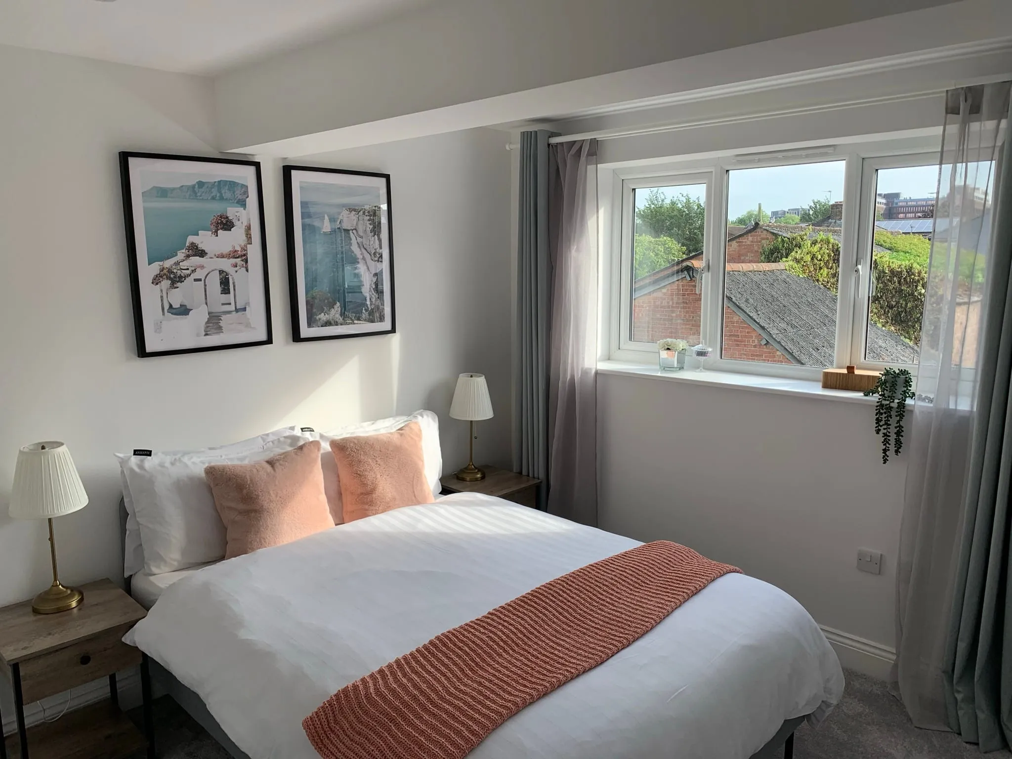 A bedroom in the extended Woking starter home, with a double bed and a window looking over neighbouring roofs