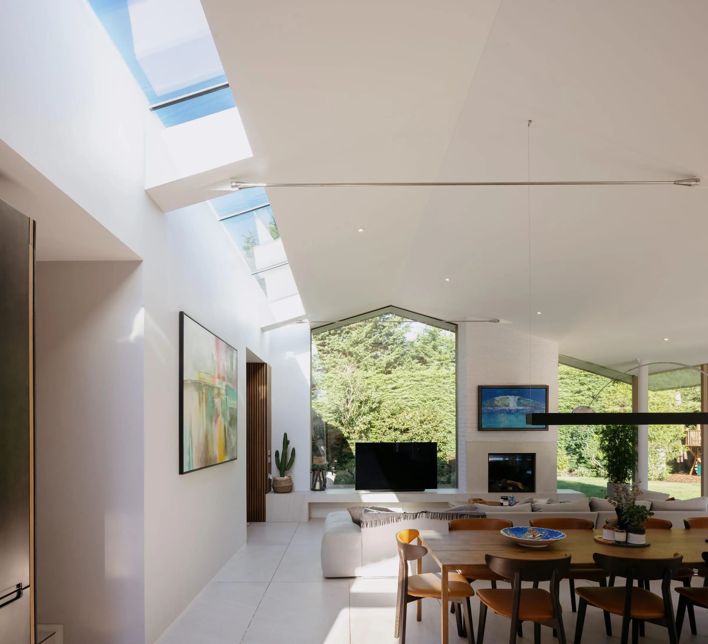 A vaulted living room under a new roof in a remodelled 1960s bungalow in Woking, with a rooflight and a fireplace