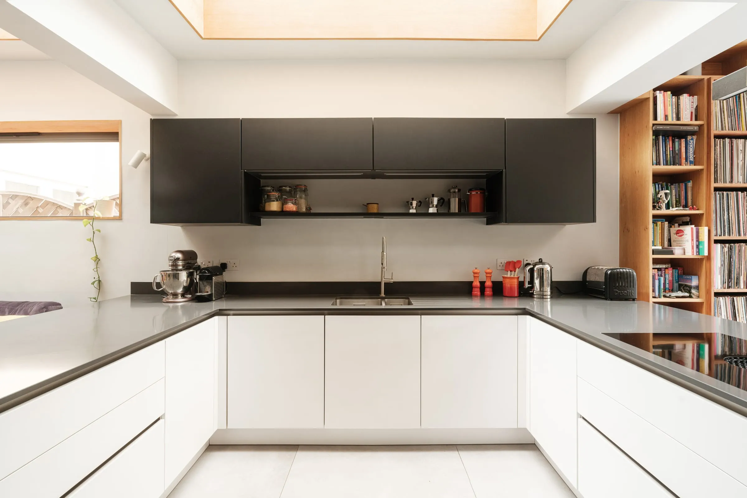 A white kitchen under a large rooflight in an East Molesey extension